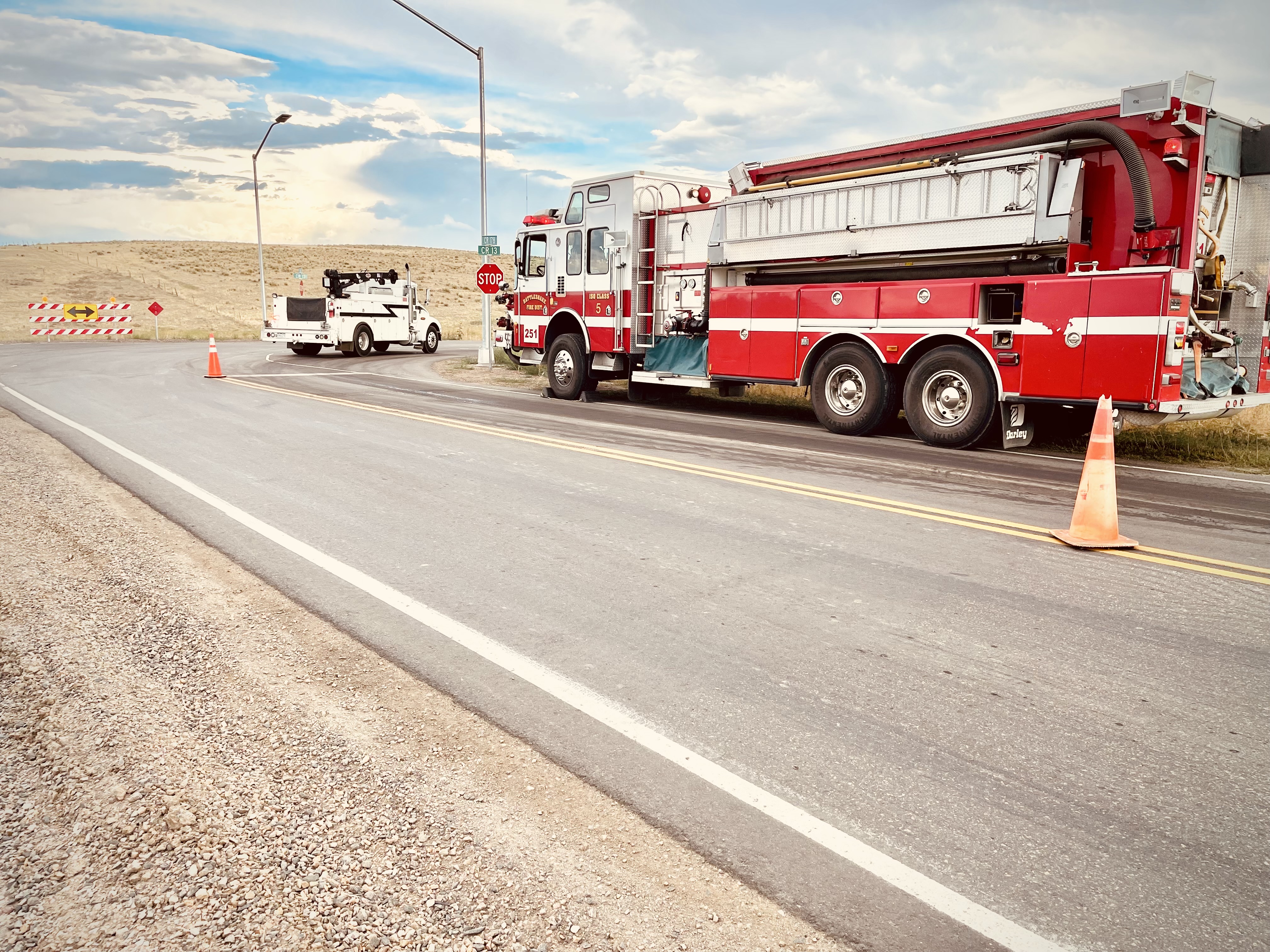 Fire truck and fleet truck on side of road with cones blocking traffic