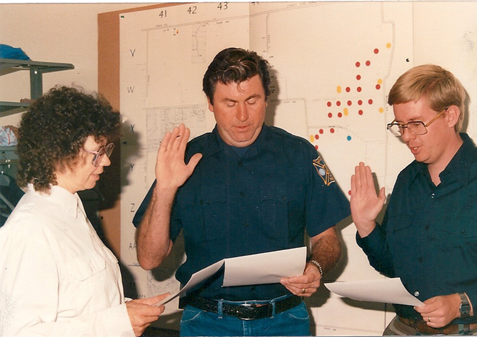 Fire Chief Judy Cooper (left) swearing in new firefighters Wally Walker (center) and David Conder (right)